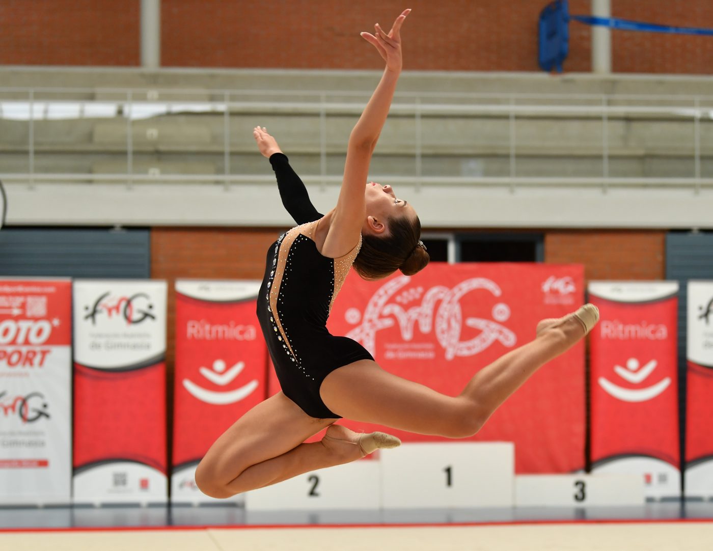 Gimnasta del club en pleno salto en una competición de la FMG