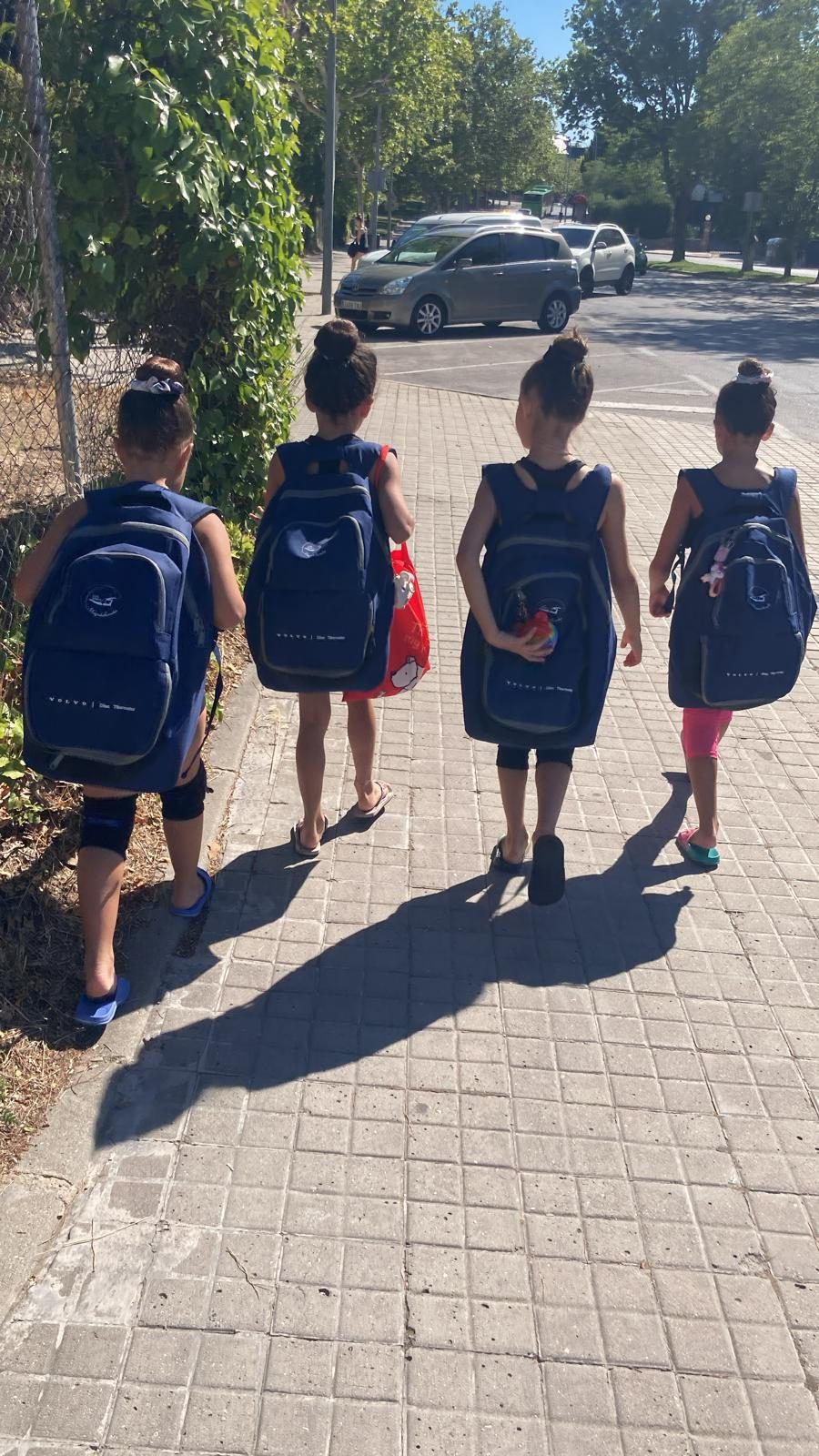 Cuatro gimnastas de camino al entrenamiento con las mochilas del club